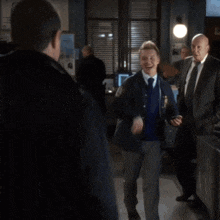 a man in a black jacket is giving another man a high five