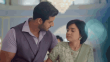 a man and a woman are standing next to each other and looking at each other