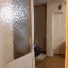 a door is open to a hallway with a light on the wall behind it