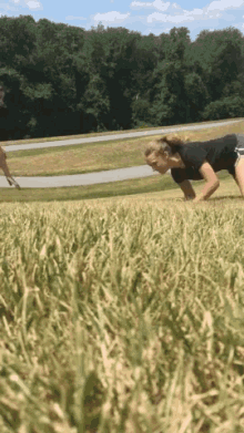 a woman is doing push ups in the grass