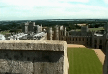an aerial view of a castle with a lush green field in front of it