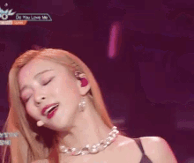 a woman singing into a microphone with the words do you love me on the bottom right