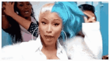 a woman with half blue and half blonde hair is standing next to a group of women .