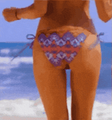 a woman in a bikini is walking along the beach