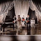 a group of people playing instruments on a stage with a piano