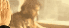 a close up of a person 's hand reaching out to touch a window .