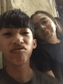 a man and a woman are posing for a picture with the woman sticking her tongue out