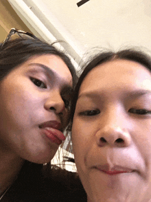 two girls sticking their tongues out at each other
