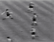 a black and white photo of a soccer goal with a person in the background .