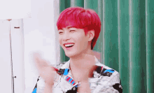 a man with red hair is laughing and clapping his hands
