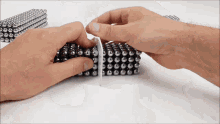 a person is holding a piece of paper over a stack of magnets