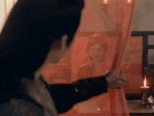 a man is looking through a red curtain at a woman in a kimono .
