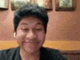 a man wearing headphones is smiling and making a funny face while sitting at a table .