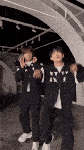 two young men are dancing and one has a jacket that says kyy x on it