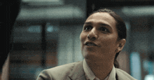 a close up of a man 's face with a ponytail