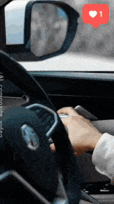 a person is driving a car with a heart shaped icon above the steering wheel