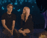 a man and a woman are sitting next to each other with candles in the background