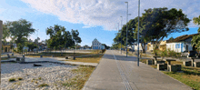 a street with a church in the background and a few benches on the sidewalk