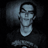 a young man is wearing a united troopers division t-shirt