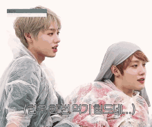 two young men are standing next to each other and one of them is wearing a plastic cover over his head