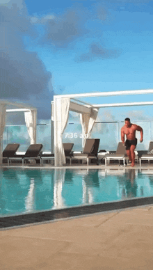 a man is jumping into a swimming pool with the time of 7:36