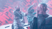 a man is covering his face with his hands in front of a crowd