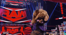 two women are wrestling in a wrestling ring with the word raw in the background