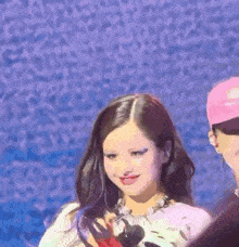 a woman in a pink shirt is standing next to a man in a pink hat on a stage .