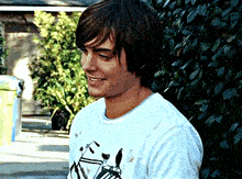 a young man wearing a white shirt with a picture of a bike on it