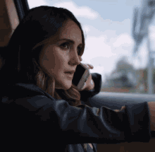 a woman is talking on a cell phone while looking out the window