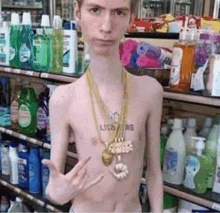 a shirtless man wearing a gold necklace with the word lion on his chest