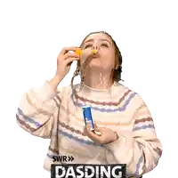 a woman in a striped sweater blowing soap bubbles with a sticker that says dasding