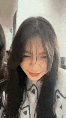 a girl with long hair is making a funny face while sitting next to another girl .