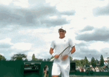 a man in a white shirt holding a tennis racquet