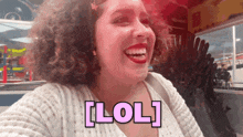 a woman with curly hair is laughing with the word lol written in pink