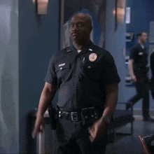 a man with a name tag that says ' tibiton ' on it stands next to a police officer