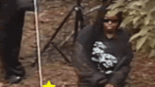 a person wearing sunglasses and a black shirt with a skull on it