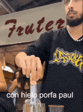 a man wearing a black shirt that says oyster is making a drink