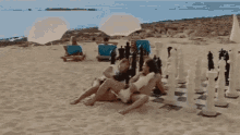 a man and a woman are having sex on the beach . the woman is wearing a bikini .