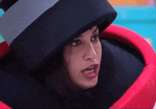 a woman wearing a black top hat and a red costume is making a funny face