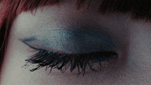 a close up of a person 's eye with blue eyeshadow