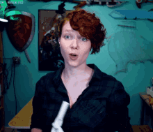 a woman in a plaid shirt holds a remote control in front of a screen that says ror esub x52