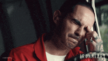 a man in a red shirt is crying with the word ironheart on the bottom