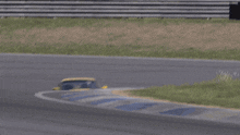 a yellow porsche is driving on a track