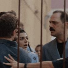 a man with a mustache is talking to a woman in a crowd