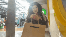 a woman is holding a brown bag that says ralph lauren