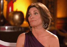 a woman in a purple dress is sitting in a chair with her eyes closed