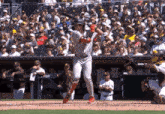 a baseball player swings his bat at a ball in front of a bank ad