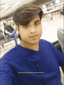 a man in a blue shirt is taking a picture of himself