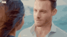 a man and a woman are looking into each other 's eyes while standing next to each other .